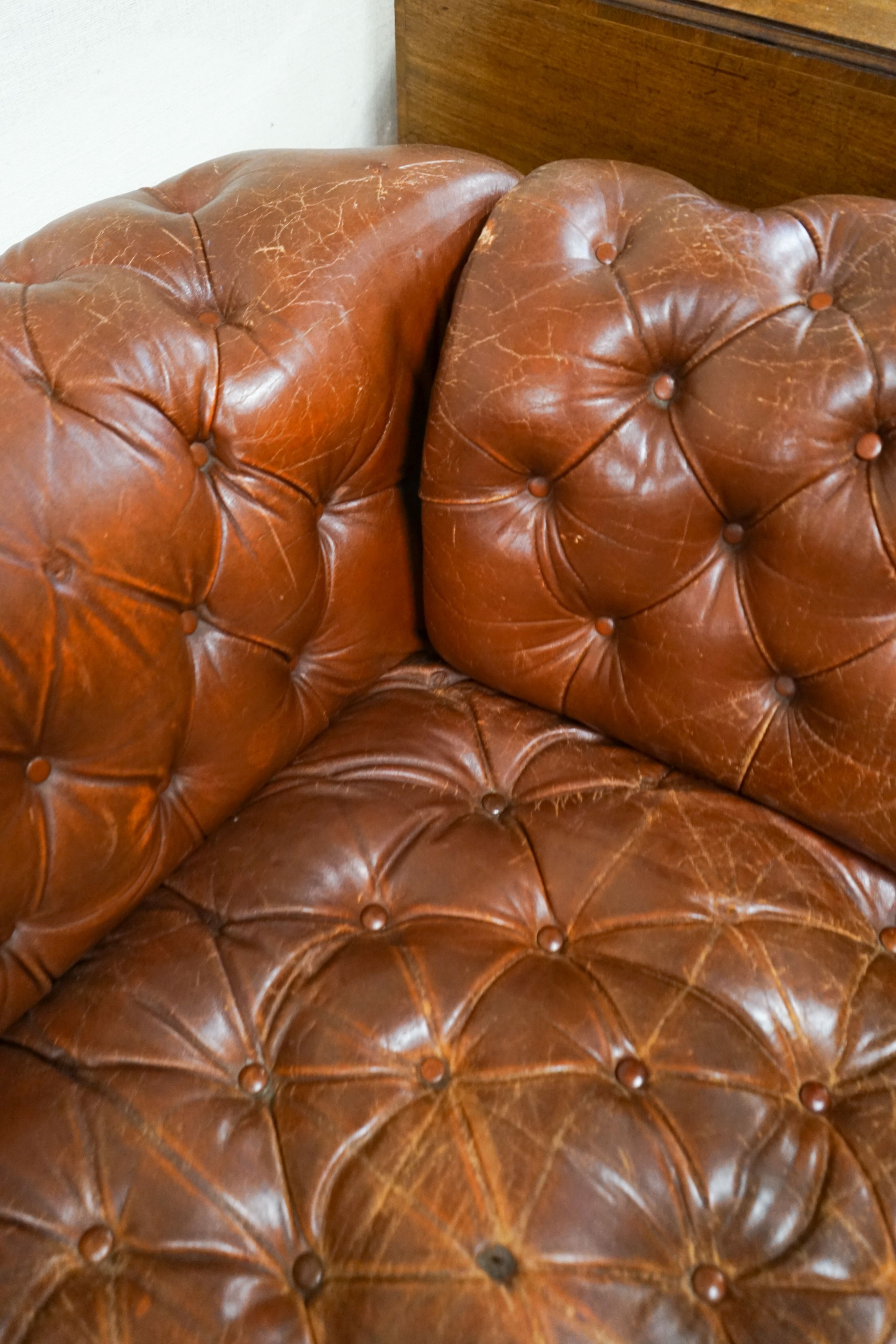 A late Victorian drop arm leather button back Chesterfield settee, length 170cm, depth 88cm, height 70cm